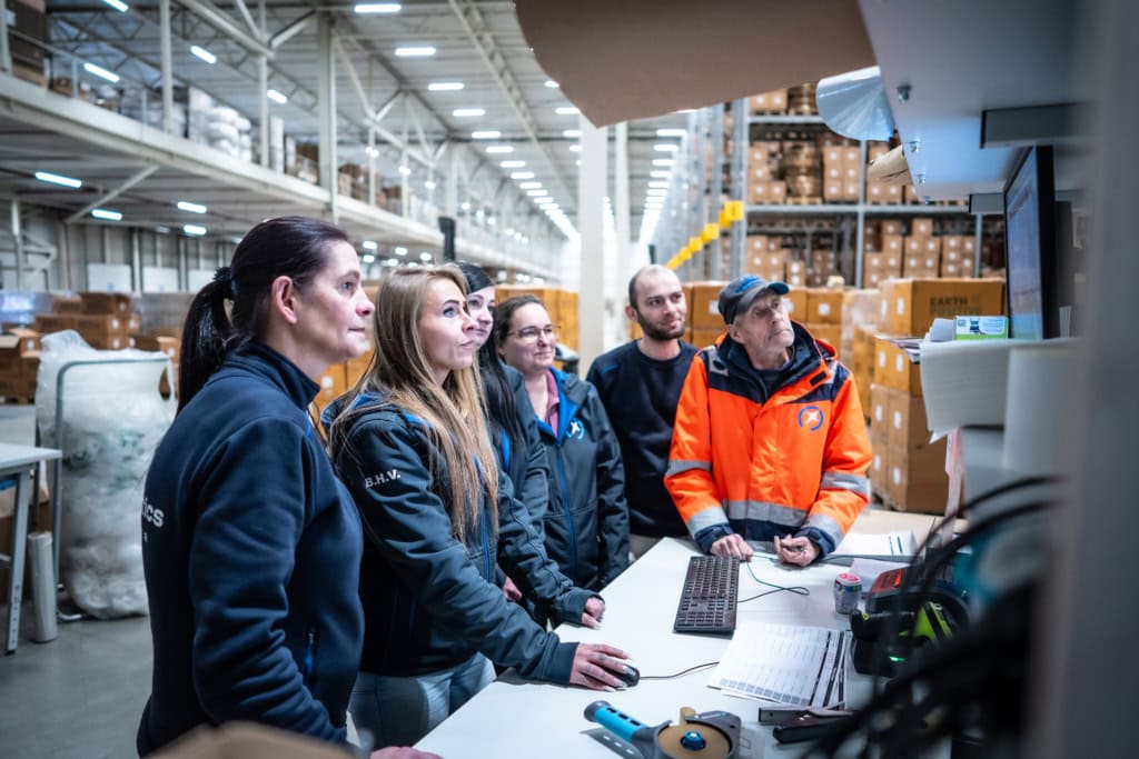 L'équipe regarde un écran à l'intérieur de l'entrepôt