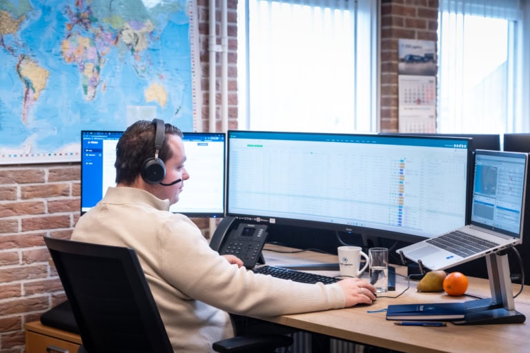 Man sitting behind desk with headphones on